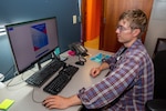 Visual Information Specialist Cole Fraser works on a graphic design project.