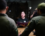 Isreali Defense Forces (IDF), Sgt. Yuval Italiano, left, and Sgt. Ofir Holzman, assigned to IDF Combat Camera Company, listen to instructions from Spc. Samantha Schaffling, assigned to 55th Signal Company (Combat Camera), in “Technical Lanes” event, during the 2023 Spc. Hilda I. Clayton Best Combat Camera Competition at Fort A.P. Hill, Virginia, May 24, 2023. The annual multi-day competition tests the physical, tactical, and technical proficiency of visual information and public affairs specialists across the DOD and participating international competitors. (U.S. Army photo by Spc. Noah Martin)