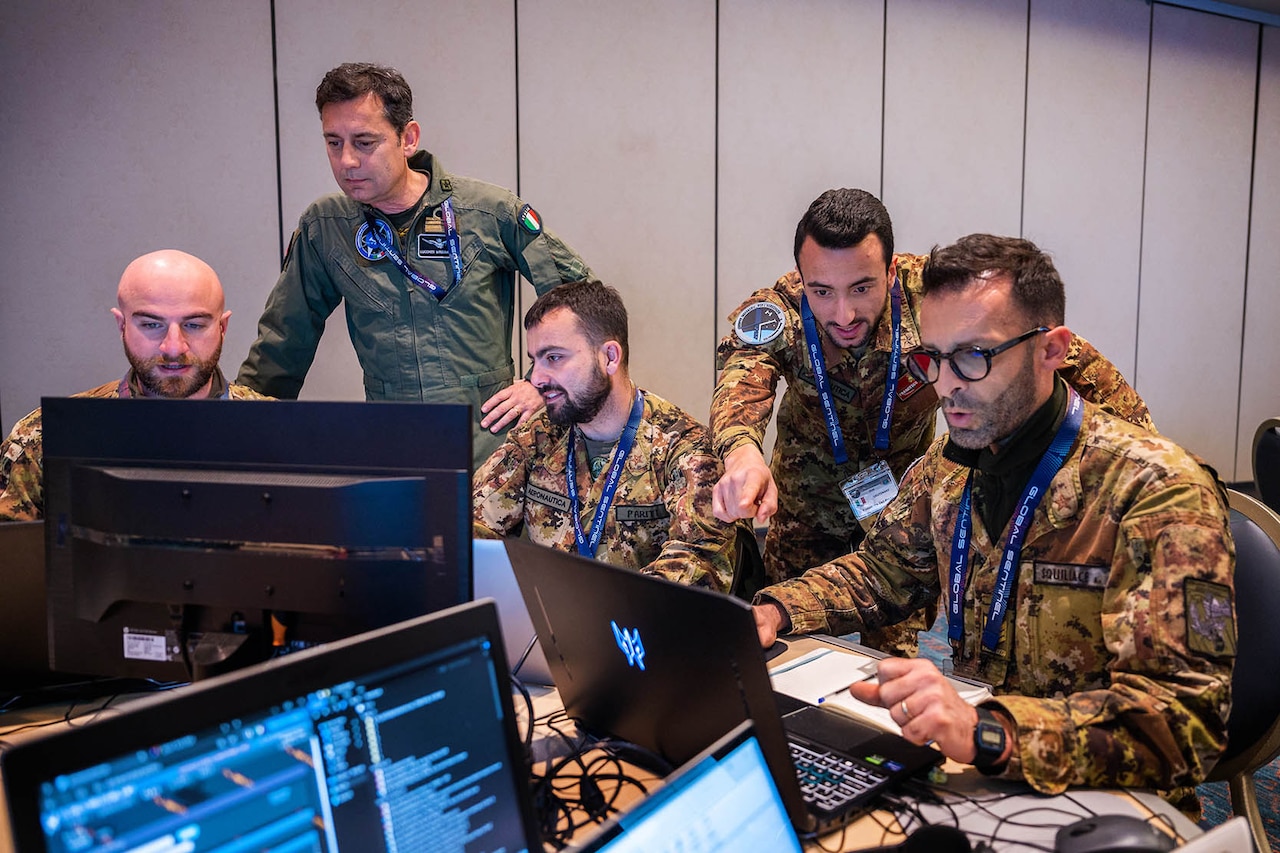 Members of a foreign military observe a computer display.