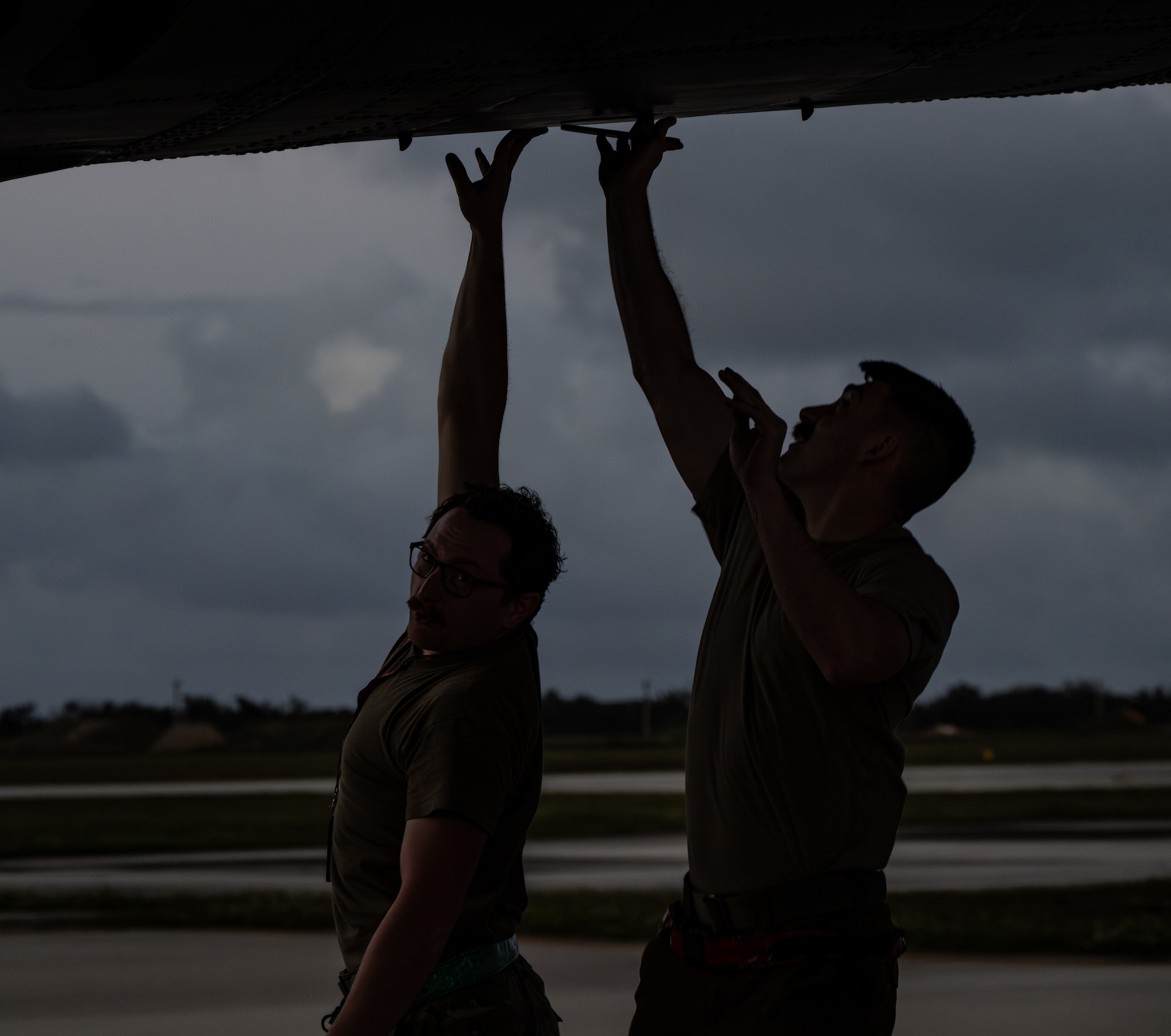 Two B-52H Stratofortress maintenance Airmen jump to close a hatch after receiving a bomber for post-flight inspection at Andersen Air Force Base, Guam, Jan. 30, 2024. Bomber missions familiarize aircrew with air bases and operations in different Geographic Combatant Commands areas of operations. The aircraft and crew are deployed from the 5th Bomb Wing at Minot Air Force Base, North Dakota. (U.S. Air Force photo by Airman 1st Class Alyssa Bankston)