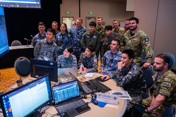 Members of a foreign military observe a computer display.