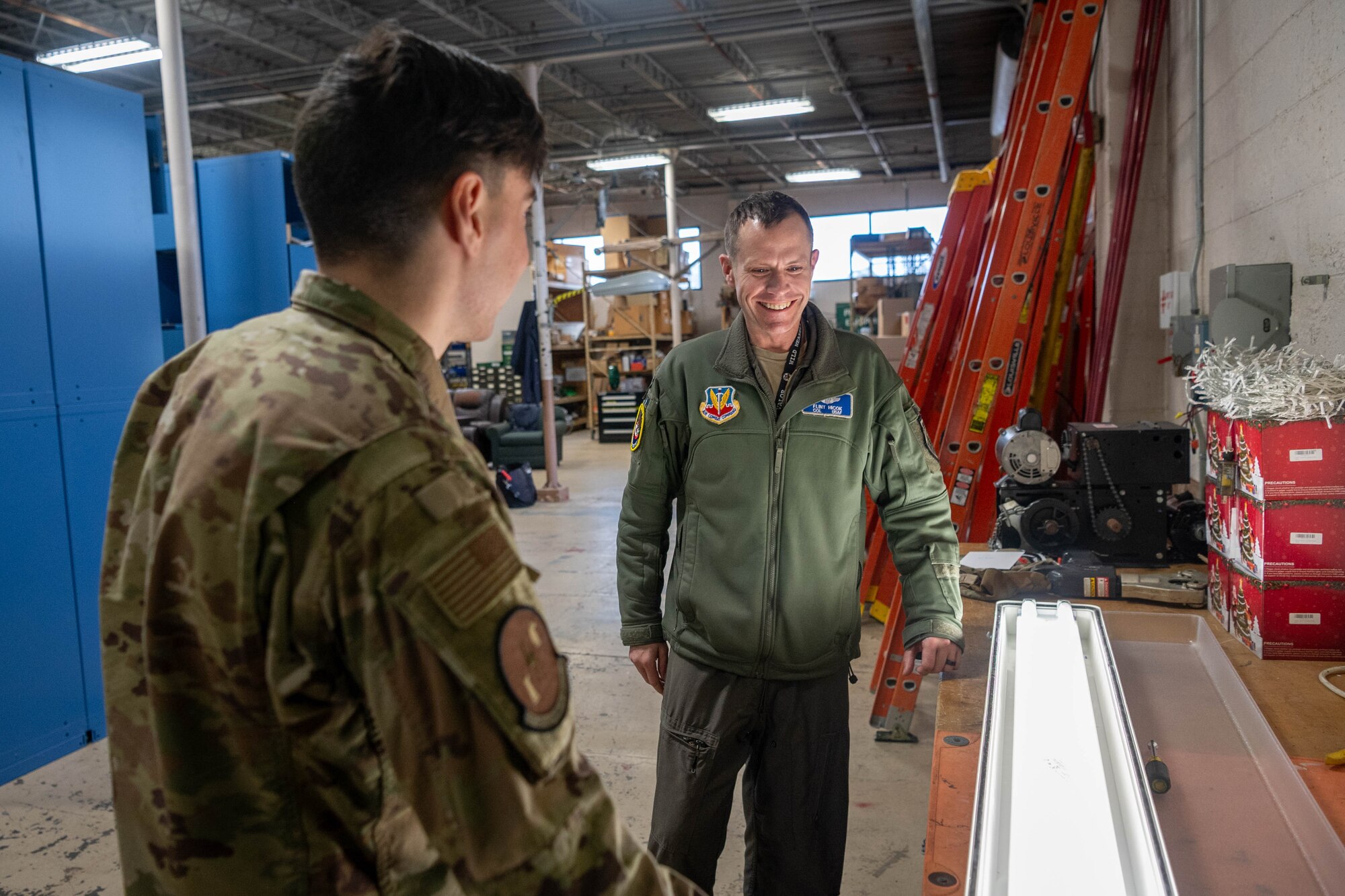 Two men standing next to a illuminated light on a table.