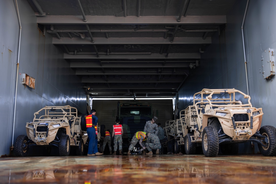 U.S. Marines with 3d Littoral Combat Team, 3d Marine Littoral Regiment, 3d Marine Division and U.S. Army Soldiers with 168th Transportation Detachment, prepare to load a Logistics Support Vessel at Waipio Point, Hawaii, Jan. 10, 2024. Bougainville III is a 3d LCT live-fire exercise focused on decentralized operations to prepare the battalion to command and control forces from dispersed locations. (U.S. Marine Corps photo by Cpl. Eric Huynh)