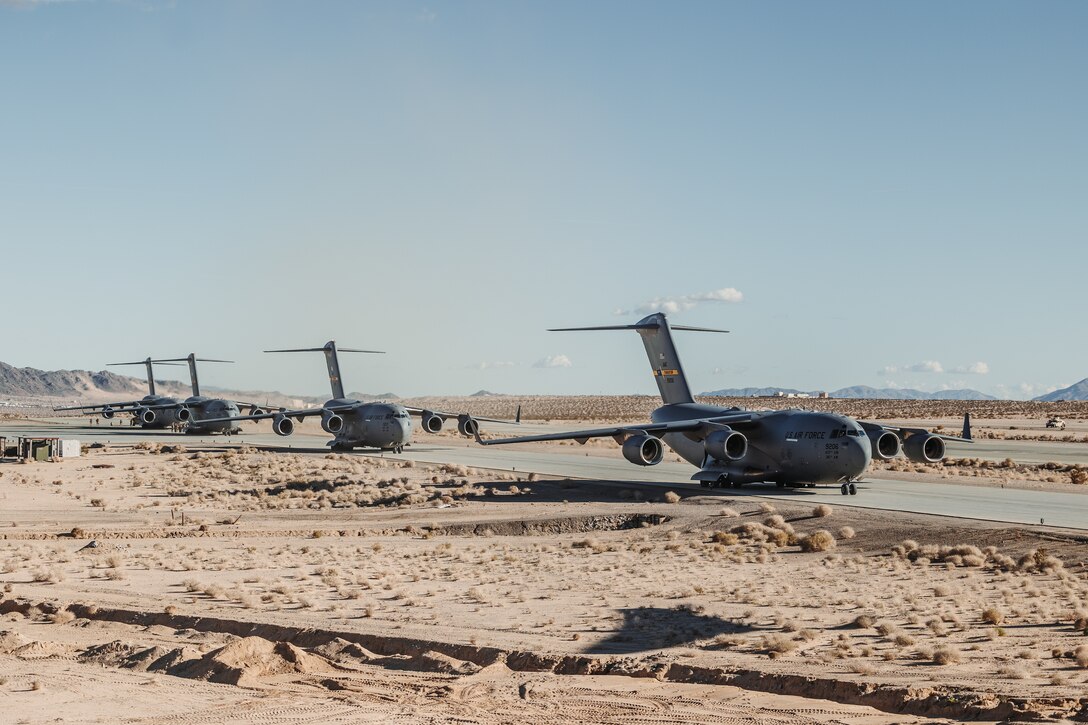 U.S. Air Force C-17 Globemaster III’s assigned to the 14th Airlift Squadron, 437th Airlift Wing, prepare to takeoff during a strategic mobility exercise as part of Service Level Training Exercise 2-24 at Camp Wilson, Marine Corps Air-Ground Combat Center, Twentynine Palms, California, Jan. 25, 2024. Joint interoperability between the Air Force and the U.S. Marine Corps enables Marine units to rapidly embark on C-17’s, allowing the Marine Corps to provide support for expeditionary operations. (U.S. Marine Corps photo by Lance Cpl. Richard PerezGarcia)