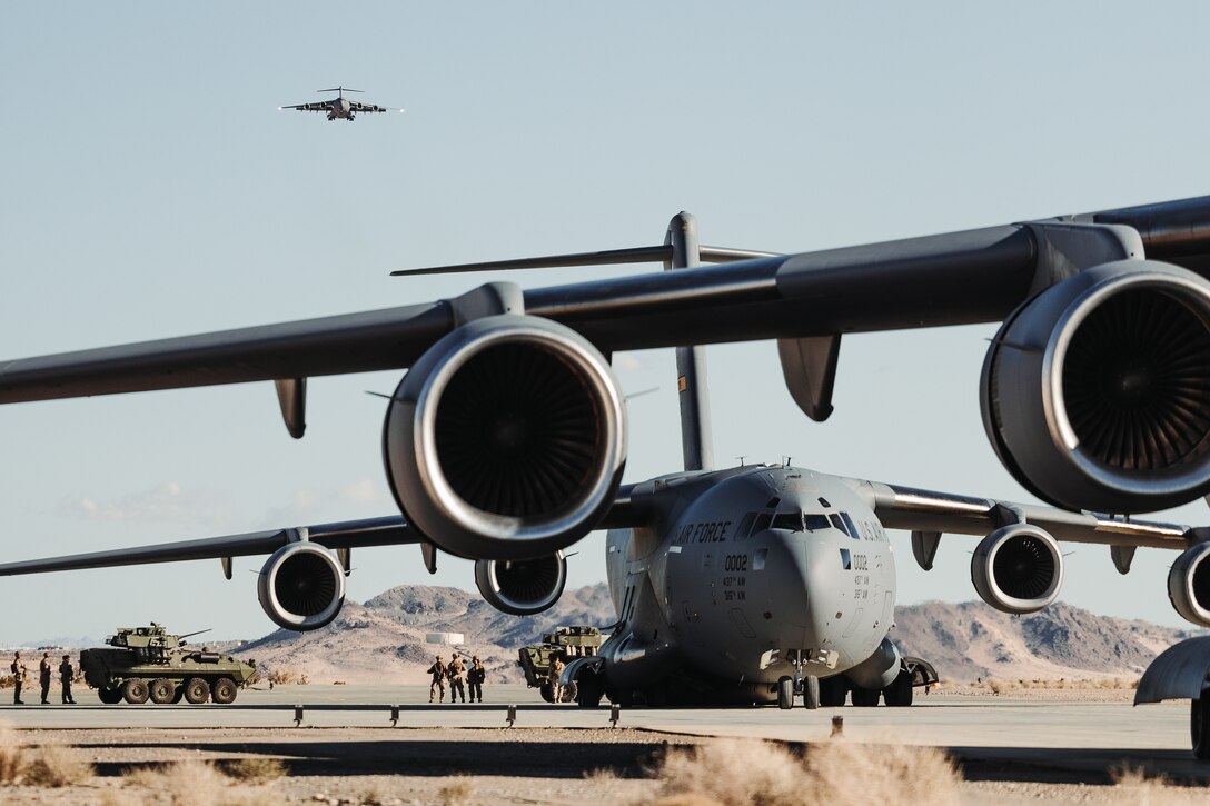U.S. Air Force C-17 Globemaster III’s assigned to the 14th Airlift Squadron, 437th Airlift Wing, prepare to load tactical vehicles during a strategic mobility exercise as part of Service Level Training Exercise 2-24 at Camp Wilson, Marine Corps Air-Ground Combat Center, Twentynine Palms, California, Jan. 25, 2024. Joint interoperability between the Air Force and the U.S. Marine Corps enables Marine units to rapidly embark on C-17’s, allowing the Marine Corps to provide support for expeditionary operations. (U.S. Marine Corps photo by Lance Cpl. Richard PerezGarcia)