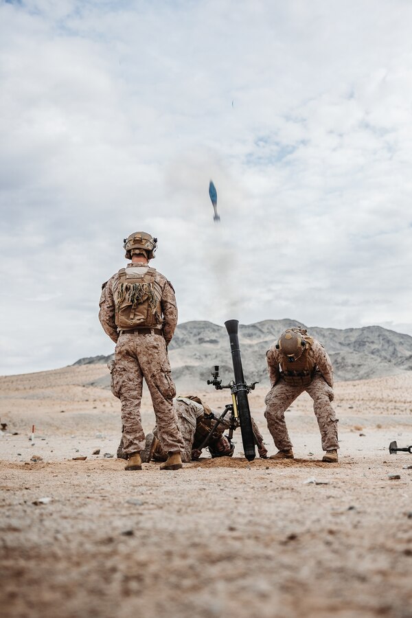 U.S. Marine Corps Cpl. Chase Ramberg, a Sandy, Oregon native, left, Lance Cpl. Serjio Cecena, a Phoenix, Arizona native, center, and Lance Cpl. Lawson Hebert, a Kankakee, Illinois native, mortarmen with 2nd Battalion, 4th Marine Regiment, 1st Marine Division, fire an 81 mm mortar round during an Integrated Training Exercise as part of Service Level Training Exercise 2-24 at Range 106A, Marine Corps Air-Ground Combat Center, Twentynine Palms, California, Jan. 20, 2024. The purpose of ITX is to create a challenging, realistic, training environment that produces combat-ready forces capable of operating as an integrated Marine Air-Ground Task Force and to prepare units for their role in the MAGTF Warfighting Exercise. (U.S. Marine Corps photo by Lance Cpl. Richard PerezGarcia)