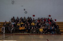 U.S. Marines and spouses participating in the "In Their Boots" and "Devil Pups" event pose for a photo at Marine Corps Recruit Depot San Diego, Feb. 16, 2024. The Devil Pups event is aimed at providing children ages 5-12 with engaging activities that introduce them to aspects of the Marine Corps lifestyle, fostering learning and discipline in a fun environment. (U.S. Marine Corps photo by Sgt. Jesse K. Carter-Powell)