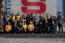 U.S. Marines and spouses taking part in the "In Their Boots" event pose for a photo at Marine Corps Recruit Depot San Diego, Feb. 16, 2024. In Their Boots is designed to inform Marine Corps spouses about the duties of their significant others and give them a peek into the rigors of recruit training. (U.S. Marine Corps photo by Sgt. Jesse K. Carter-Powell)