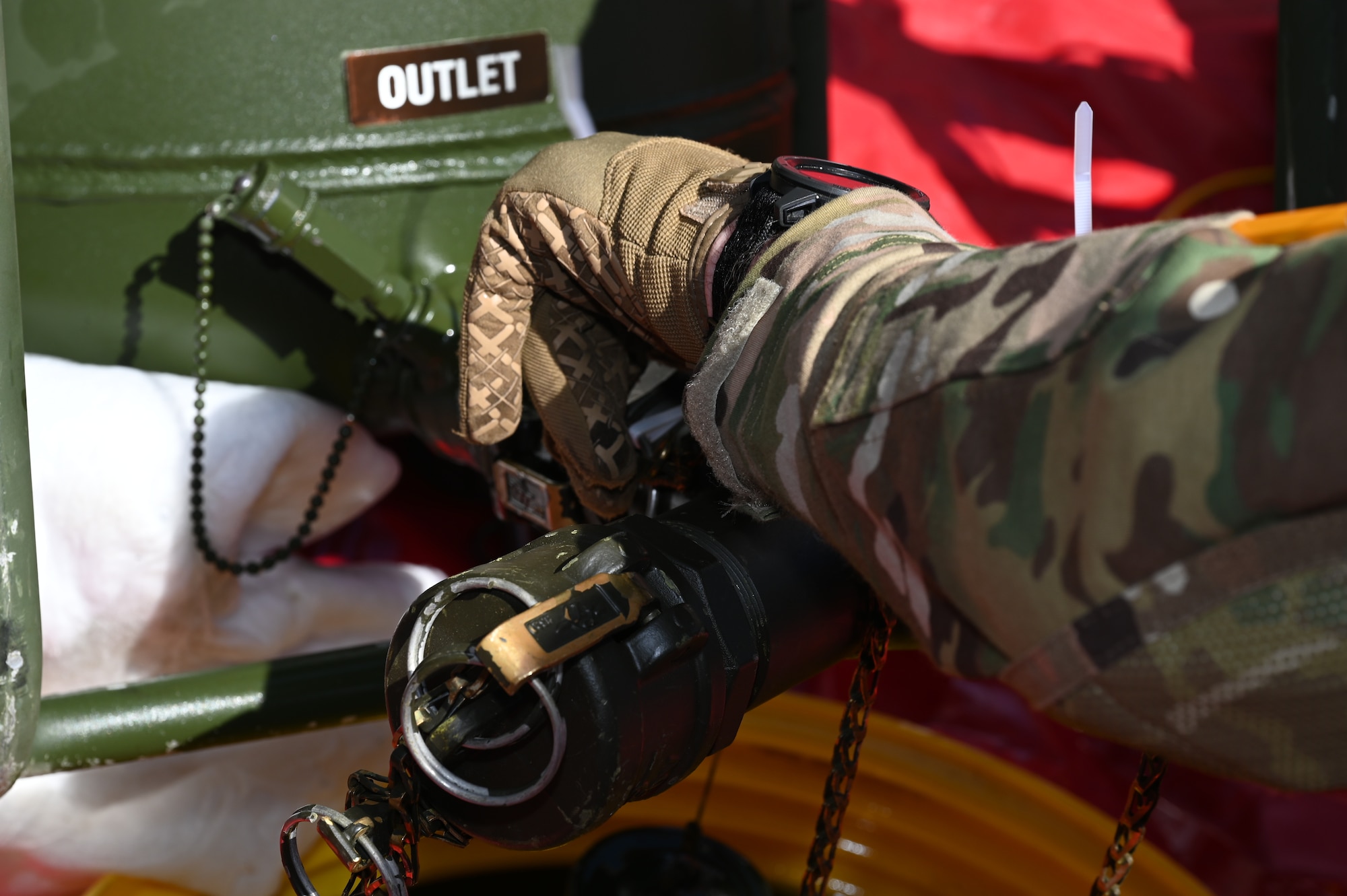 An Airman pulls a fuel sample while using gloves.