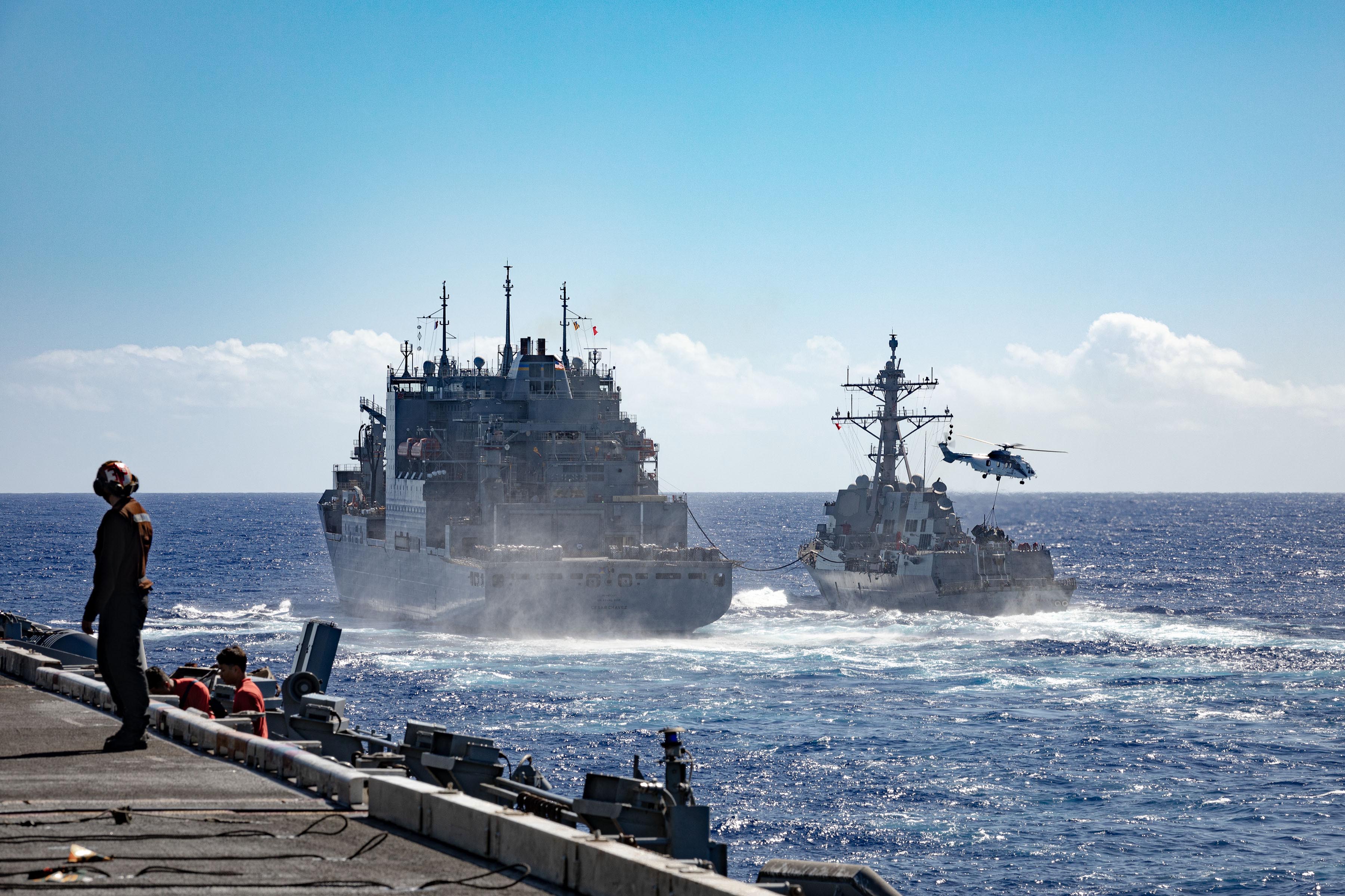 The Lewis and Clark-class dry cargo ship USNS Cesar Chavez (T-AKE 14) refuels the Arleigh Burke-class guided-missile destroyer USS Rafael Peralta (DDG 115) while conducting a replenishment-at-sea with the Nimitz-class aircraft carrier USS Theodore Roosevelt (CVN 71)
