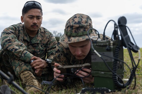 U.S. Marines Lance Cpl. Christian Montemayor, a fire support Marine, left, and Sgt. John Philips a transmissions system operator, right, both with 5th Air Naval Gunfire Liaison Company, III Marine Expeditionary Force Information Group, conduct a communications check during a field exercise, Rapid Tanto at Ie Shima, Okinawa, Japan, Feb. 6, 2024. The radio allowed transmission of data to higher headquarters. Using off-the-shelf radars and low-signature equipment, 5th ANGLICO and 3rd Intelligence Battalion demonstrated proficiency in planning, coordination, and execution of dynamic targeting capable of supporting maritime campaigns in an increasingly contested Indo-Pacific. Philips is a native of Gaffney SC, and Montemayor is a native of San Diego. (U.S. Marine Corps photo by Cpl. William Wallace)