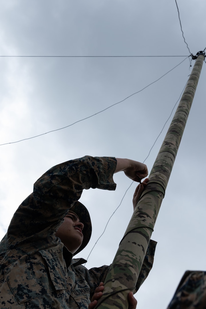 U.S. Marine Corps Sgt. Heriberto Rayescandelario, a data systems administrator with 5th Air Naval Gunfire Liaison Company, III Marine Expeditionary Force Information Group, sets up a radio during a communications field exercise, Rapid Tanto at Ie Shima, Okinawa, Japan, Feb. 5, 2024. The radio allowed transmission of data to higher headquarters. Using off-the-shelf radars and low-signature equipment, 5th ANGLICO and 3rd Intelligence Battalion demonstrated proficiency in planning, coordination, and execution of dynamic targeting capable of supporting maritime campaigns in an increasingly contested Indo-Pacific. Rayescandelario is a native of San Juan, Puerto Rico. (U.S. Marine Corps photo by Cpl. William Wallace)