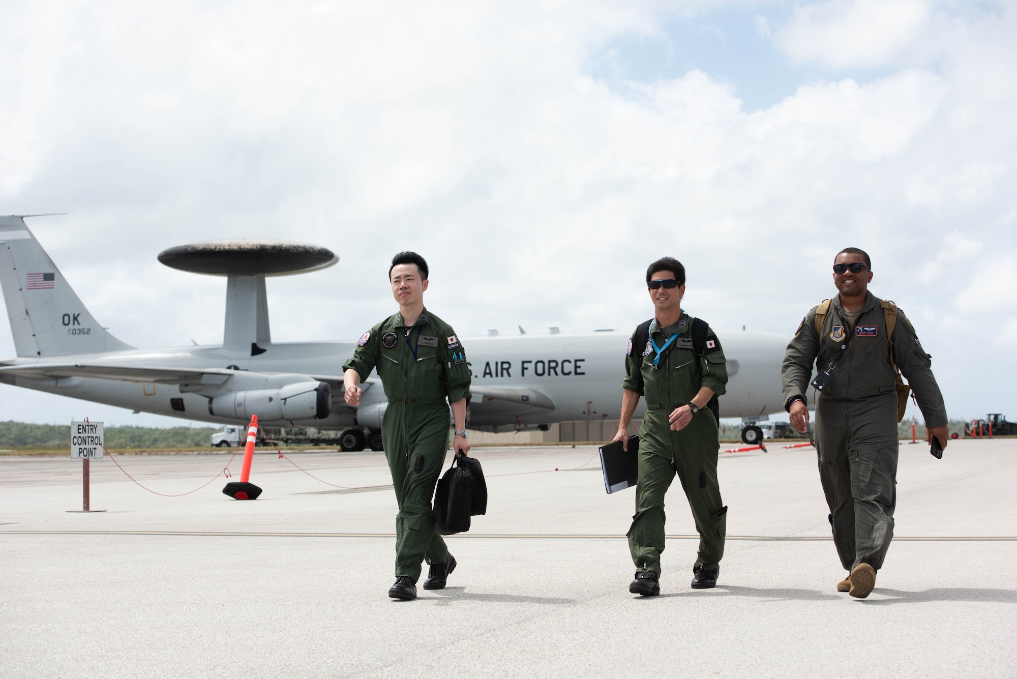 JASDF and USAF aircrew walk towards an aircraft.