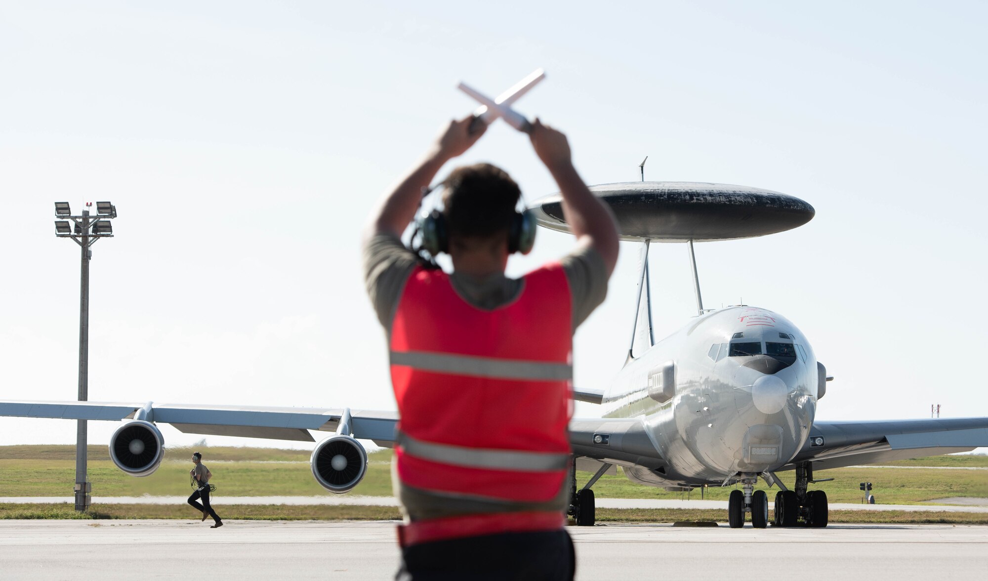A crew chief marshals an aircraft.