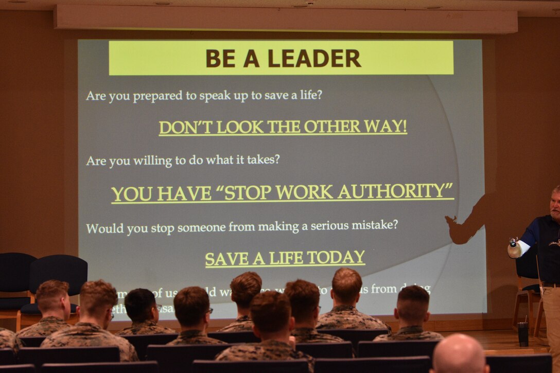 Lee Shelby stands next to a presentation slide while encouraging Marines to think about safety at Combined Arms Training Center, Camp Fuji, Japan, February 16, 2024. (U.S. Marine Corps photo by Song Jordan)