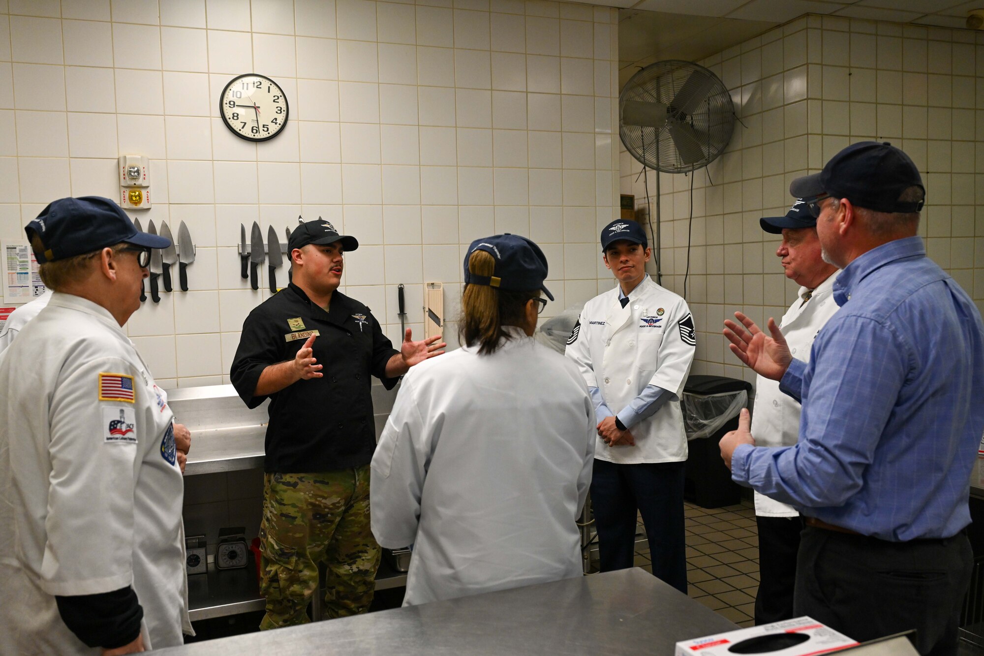 Airman 1st Class Christopher Blandino, 22nd Force Support Squadron food service apprentice, talks to the Hennessy Award critics at McConnell Air Force Base, Kansas, Feb. 15, 2024. The Hennessy Award is an annual recognition given to the base with the best dining facility in the Air Force. (U.S. Air Force photo by Airman 1st Class William Lunn)