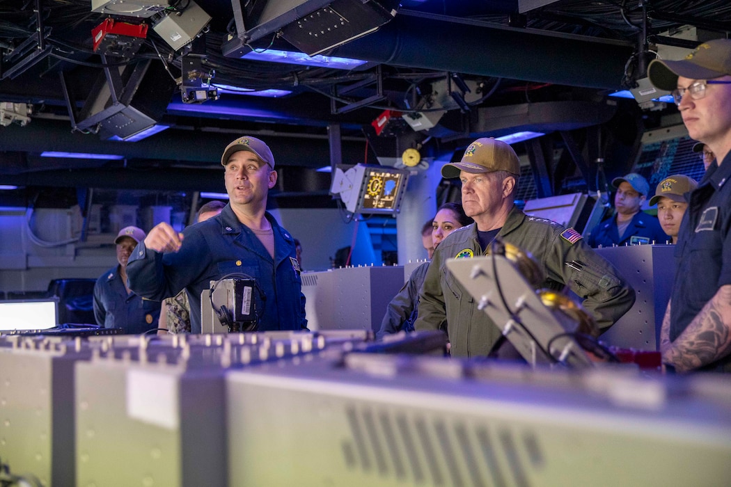 Cmdr. Nathaniel Chase, left, speaks with Adm. Samuel Paparo in the combat information center aboard USS Preble (DDG 88) during a tour of the ship.