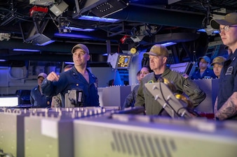 Cmdr. Nathaniel Chase, left, speaks with Adm. Samuel Paparo in the combat information center aboard USS Preble (DDG 88) during a tour of the ship.