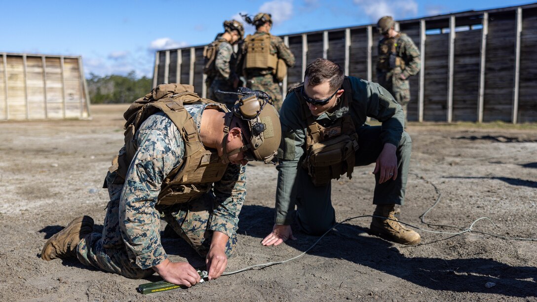 U.S. Marine Corps Sgt. Mitchel Swafford, right, an explosive ordnance disposal technician with 8th Engineer Support Battalion, Combat Logistics Battalion 27, 2nd Marine Logistics Group, supervises Cpl. Jayden Johnson, a rifleman with 3rd Battalion, 2nd Marine Regiment, 2nd Marine Division, placing a fuse in a block of C4 during a basic demolition range on Camp Lejeune, North Carolina, Feb. 13, 2024. The training exposed 2nd MLG and 2nd Marine Division Marines to the EOD program, enhancing their baseline understanding of EOD and generate interest as potential lateral move candidates . (U.S. Marine Corps photo by Cpl. Alfonso Livrieri)