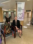 Brigid Herrick, the Chief Experience Officer (CXO) at Walter Reed National Military Medical Center, poses with one of the hospital's emotional support dogs outside of the Outpatient Phlebotomy Laboratory in Building 9 at Walter Reed in Bethesda, Maryland.