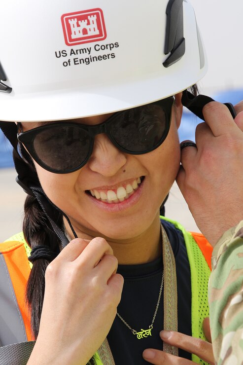 Person gets help with safety helmet strap.