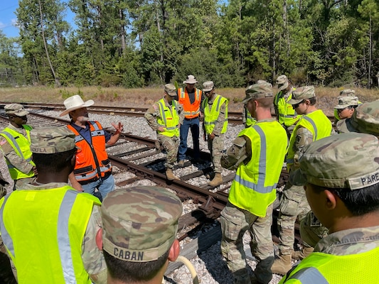 Lead Instructor Mike Crawford advises a group of program participants during a railroad training exercise.