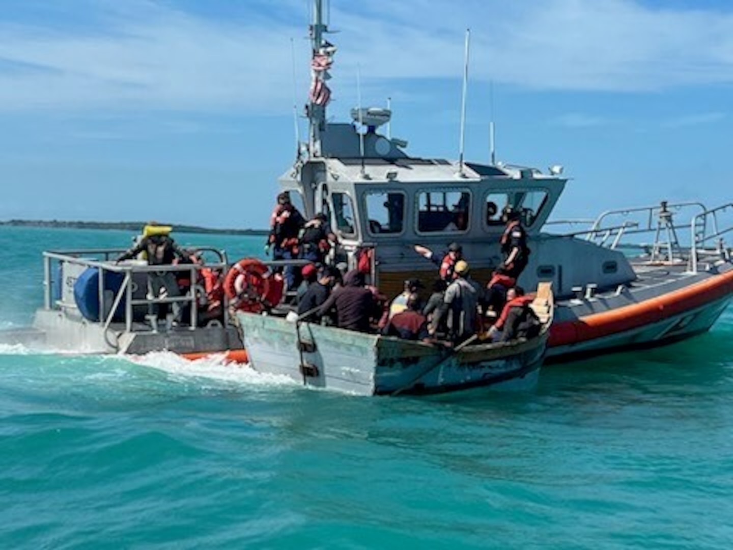 Boat with migrants aboard adjacent to Coast Guard small boat. Second picture depicts the vessel disembarked.