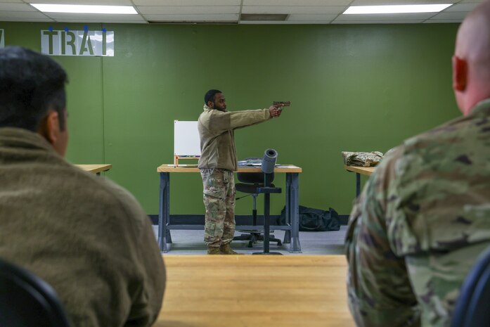 U.S. Air Force Senior Airman Johnathan Gibbs, 9th Security Forces Squadron Combat Arms Training and Maintenance (CATM) instructor, demonstrates proper shooting techniques during the Tactical Response Team (TRT) tryouts Feb. 12, 2024, at Beale Air Force Base, California.