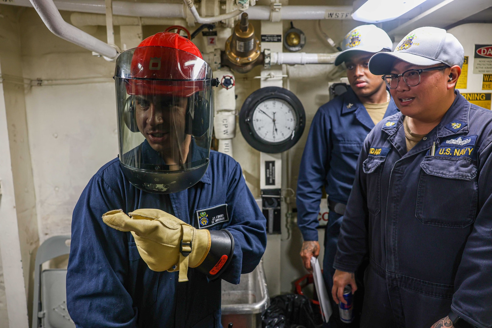 Sailors gather around some machinery.