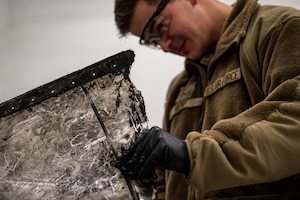 Airman 1st Class Gavin Remp, 305th Maintenance Squadron structural maintenance journeyman assesses damage to a C-17 Globemaster III panel at Joint Base McGuire-Dix-Lakehurst, N.J., Feb 15, 2024. Maintainers from the 305th MXS completed a five-month fabrication project for a damaged C-17, reaffirming Air Mobility Command’s strategic advance and rapid global mobility. (U.S. Air Force photo by 2nd Lt. Alexis Kula)