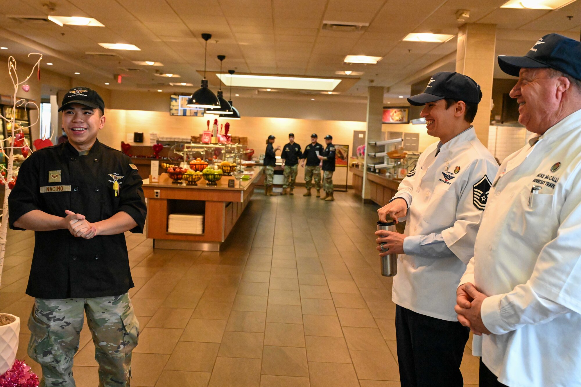 Senior Airman Shane Nacino, 22nd Force Support Squadron food service apprentice, greets the Hennessy Award critics at McConnell Air Force Base, Kansas, Feb. 15, 2024. The Hennessy Award is an annual recognition given to the base with the best dining facility in the Air Force. (U.S. Air Force photo by Airman 1st Class William Lunn)