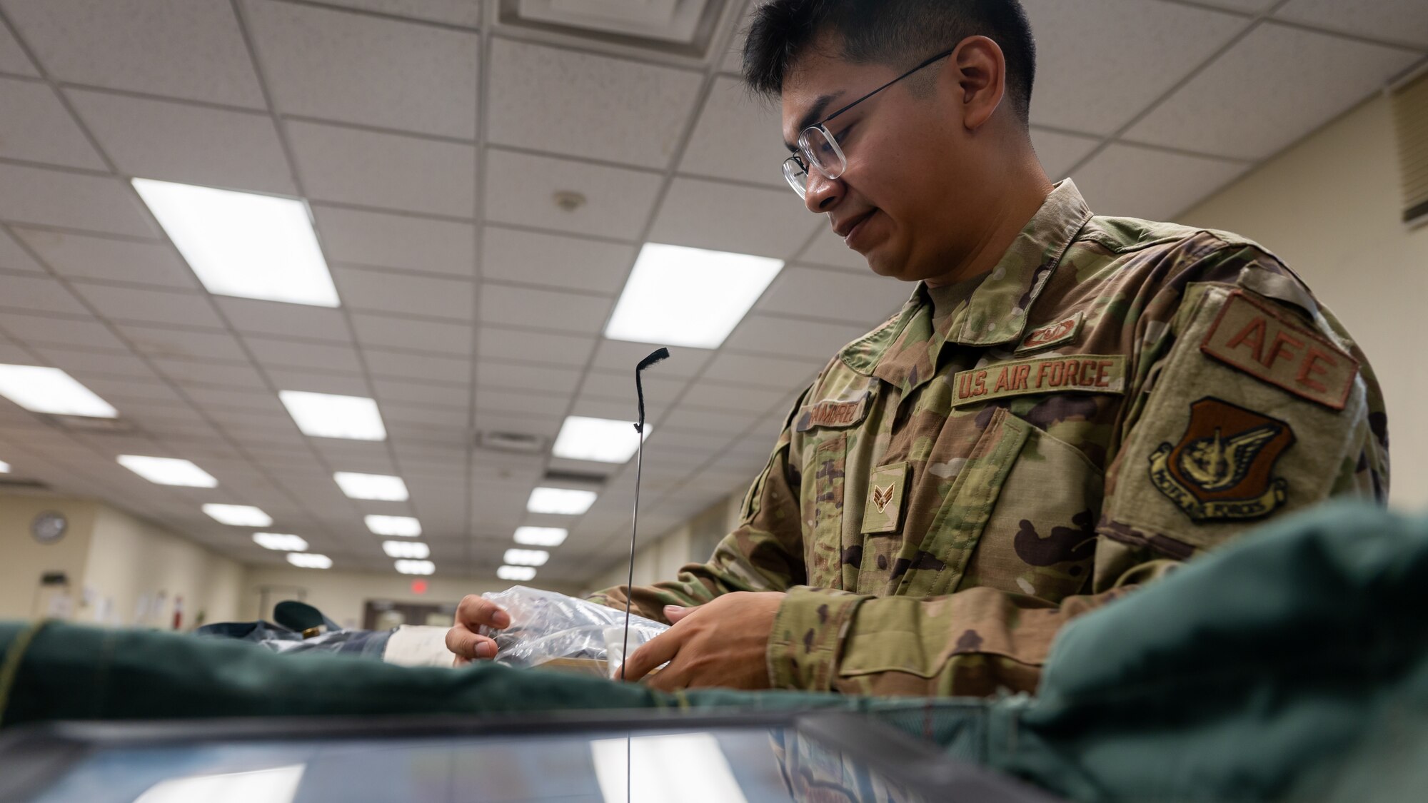 Senior Airman Andrew Rameriz inspects items within a survival kit at Kunsan Air Base.