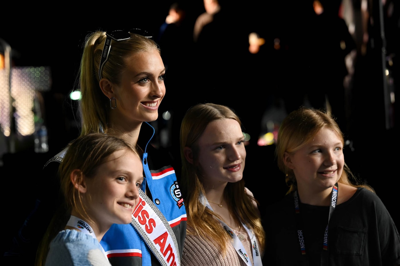 Air Force 2nd Lt. Madison Marsh, Miss America 2024, takes a photo with three young students.