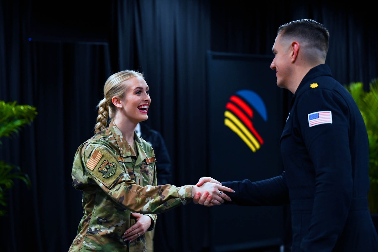 Air Force 2nd Lt. Madison Marsh, Miss America 2024, shakes hand with a member of the Thunderbirds flight demonstration squadron.