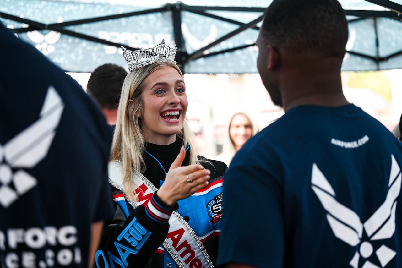 Miss America speaks with a member of a group of enlistees.