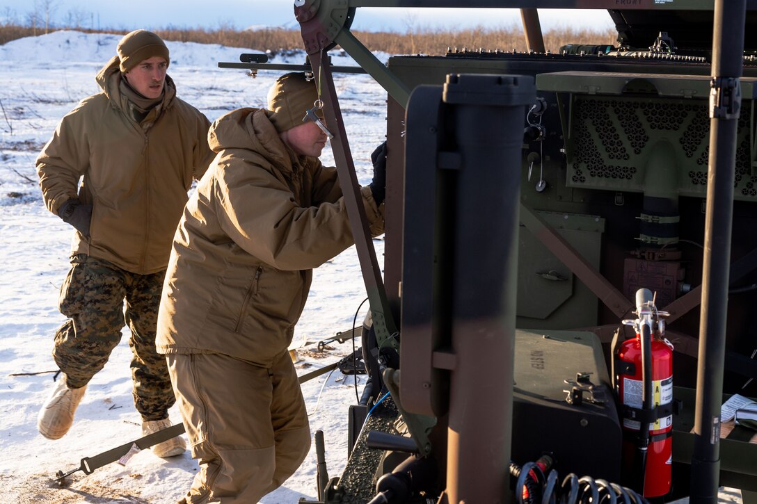 U.S. Marine Corps Cpl. Toby Callaway (left), a radar technician with Marine Air Control Squadron 24 (MACS-24), Marine Air Control Group 48, 4th Marine Aircraft Wing, Marine Forces Reserve assists Lance Cpl. Mathew Colley (right), another radar technician with MACS-24, to initialize an AN/TPS-80 Ground/Air Task Oriented Radar (G/ATOR) in preparation of Exercise ARCTIC EDGE 2024 at Fort Greely, Alaska, Feb. 10, 2024. The G/ATOR was utilized to perform radar picture and command and control functions in an arctic environment. ARCTIC EDGE 2024 (AE24) is a U.S. Northern Command-led homeland defense exercise demonstrating the U.S. military’s capabilities in extreme cold weather, joint force readiness, and U.S. military commitment to mutual strategic security interests in the arctic region. (U.S. Marine Corps photo by Lance Cpl. Madisyn Paschal)