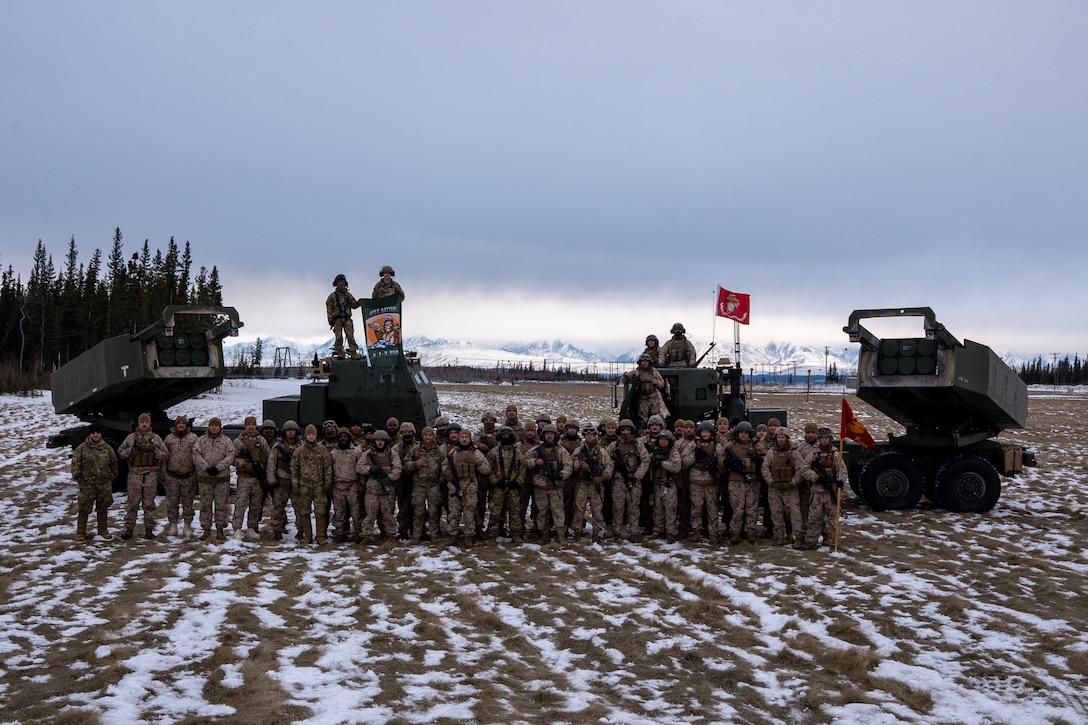U.S. Marine Corps and U.S. Army service members pose for a photo after completing joint High Mobility Artillery Rocket System (HIMARS) drills in preparation of exercise Arctic Edge 2024 in Fort Greely, Alaska, Feb. 18, 2024. Joint HIMAR drills allow both services to collaborate in order to ensure readiness in real-life scenarios. The HIMARS weapon system is a highly mobile artillery rocket system that fires six guided missiles in quick succession. ARCTIC EDGE 2024 (AE24) is a U.S. Northern Command-led homeland defense exercise demonstrating the U.S. military’s capabilities in extreme cold weather, joint force readiness, and U.S. military commitment to mutual strategic security interests in the Arctic region.(U.S. Marine Corps photo by Lance Cpl. Kanoa Thomas).