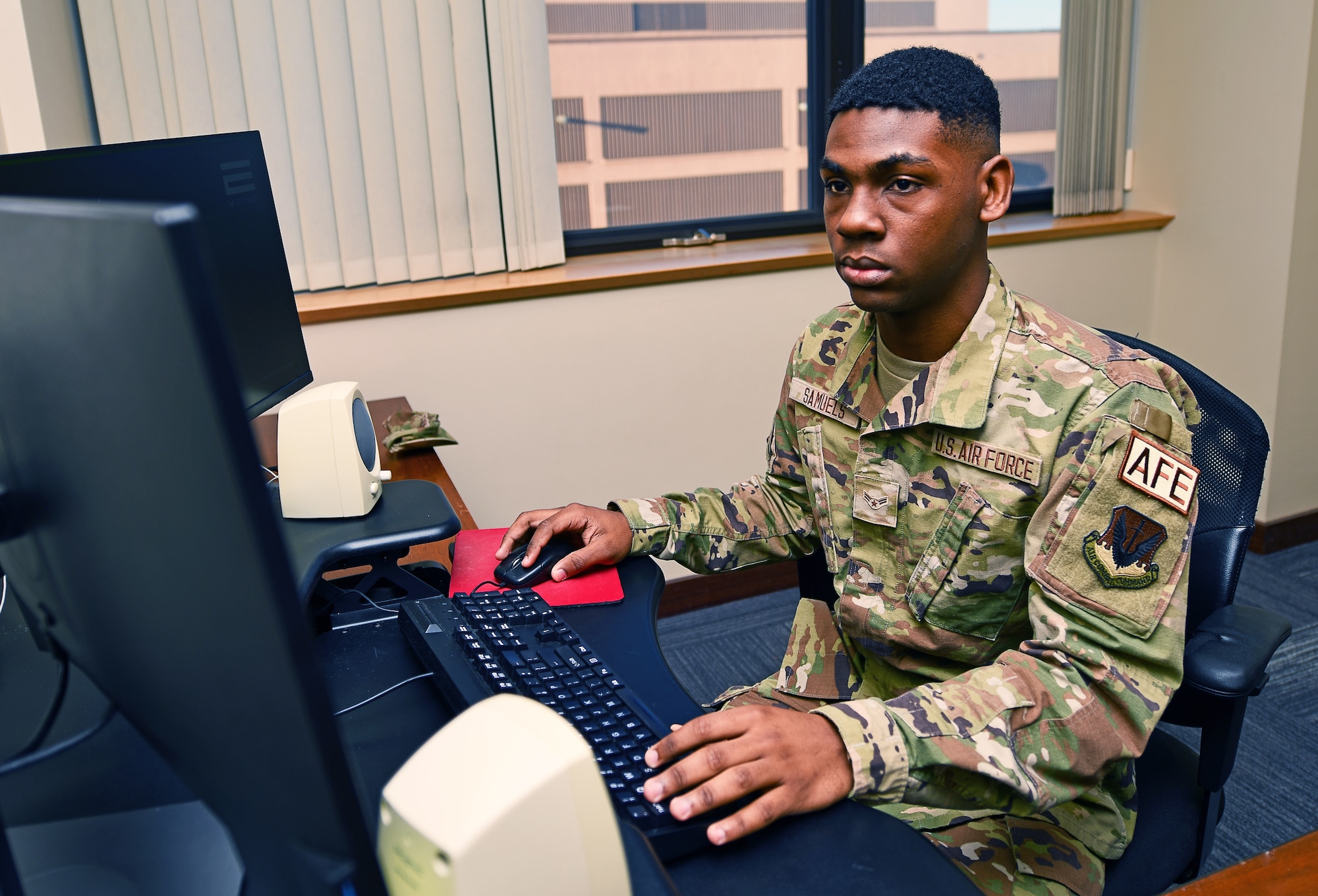 An airman takes a test at a computer