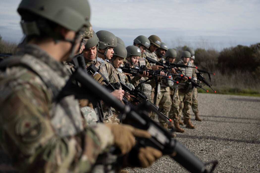 Airmen stand in a line holding weapons.