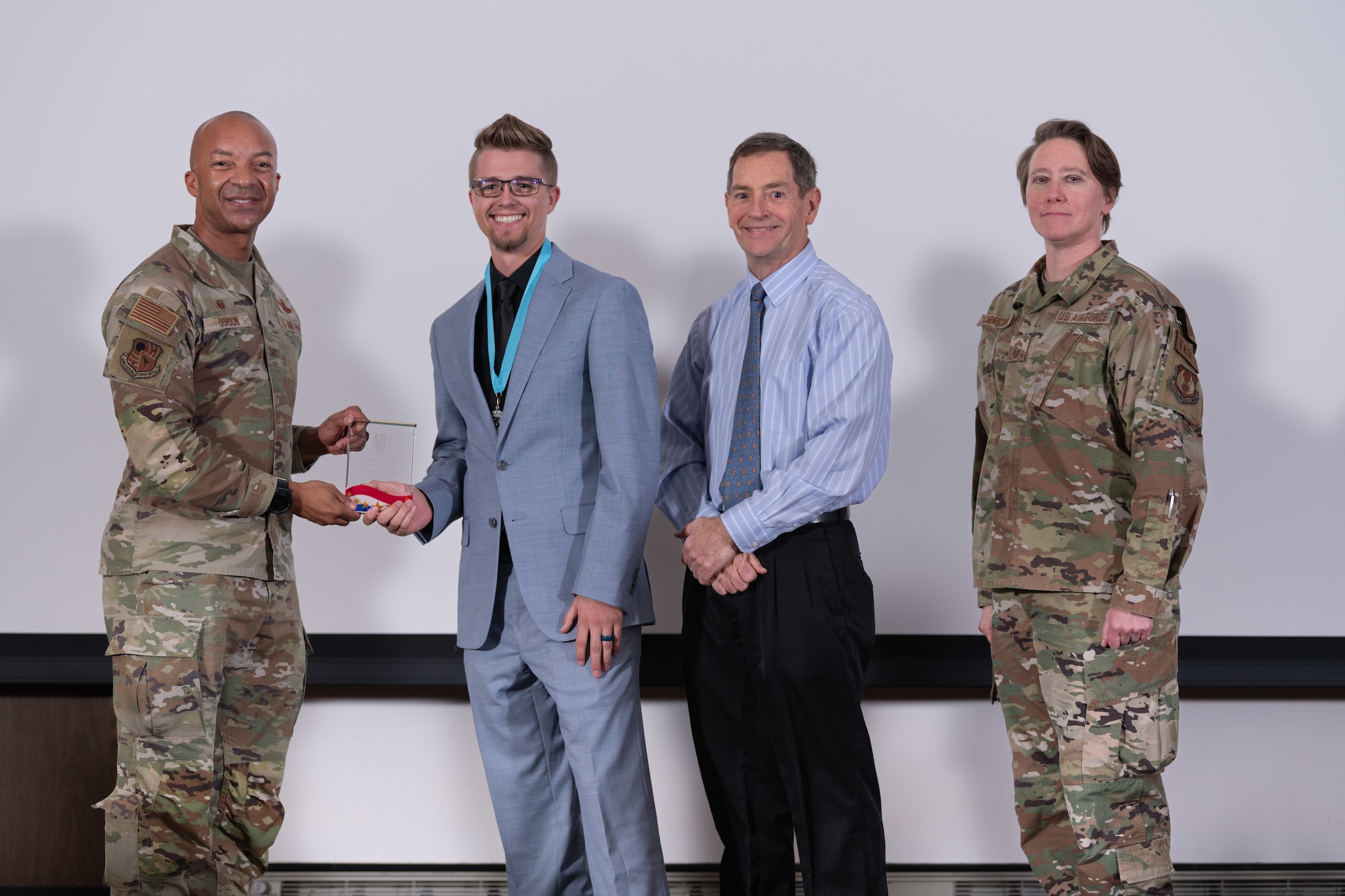 Joshua Anders with the 846th Test Squadron, second from left, accepts the award for Category III Civilian of the Year during the Arnold Engineering Development Complex Annual Awards ceremony Feb. 15, 2024, at Arnold Air Force Base, Tenn. Also pictured are AEDC Commander Col. Randel Gordon, left, AEDC Deputy Director Kevin Muckerheide and AEDC Senior Enlisted Leader Chief Master Sgt. Jennifer Cirricione. (U.S. Air Force photo by Keith Thornburgh)