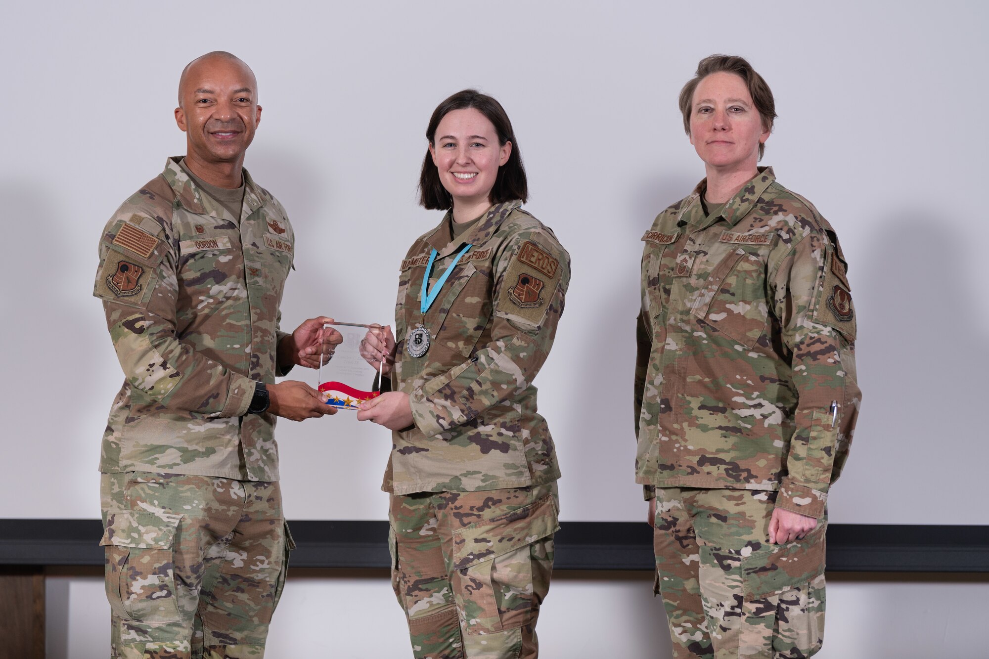 1st Lt. Camden Dammeyer with the 716th Test Squadron, center, accepts the award for Company Grade Officer of the Year during the Arnold Engineering Development Complex Annual Awards ceremony Feb. 15, 2024, at Arnold Air Force Base, Tenn. Also pictured are AEDC Commander Col. Randel Gordon and AEDC Senior Enlisted Leader Chief Master Sgt. Jennifer Cirricione. (U.S. Air Force photo by Keith Thornburgh)