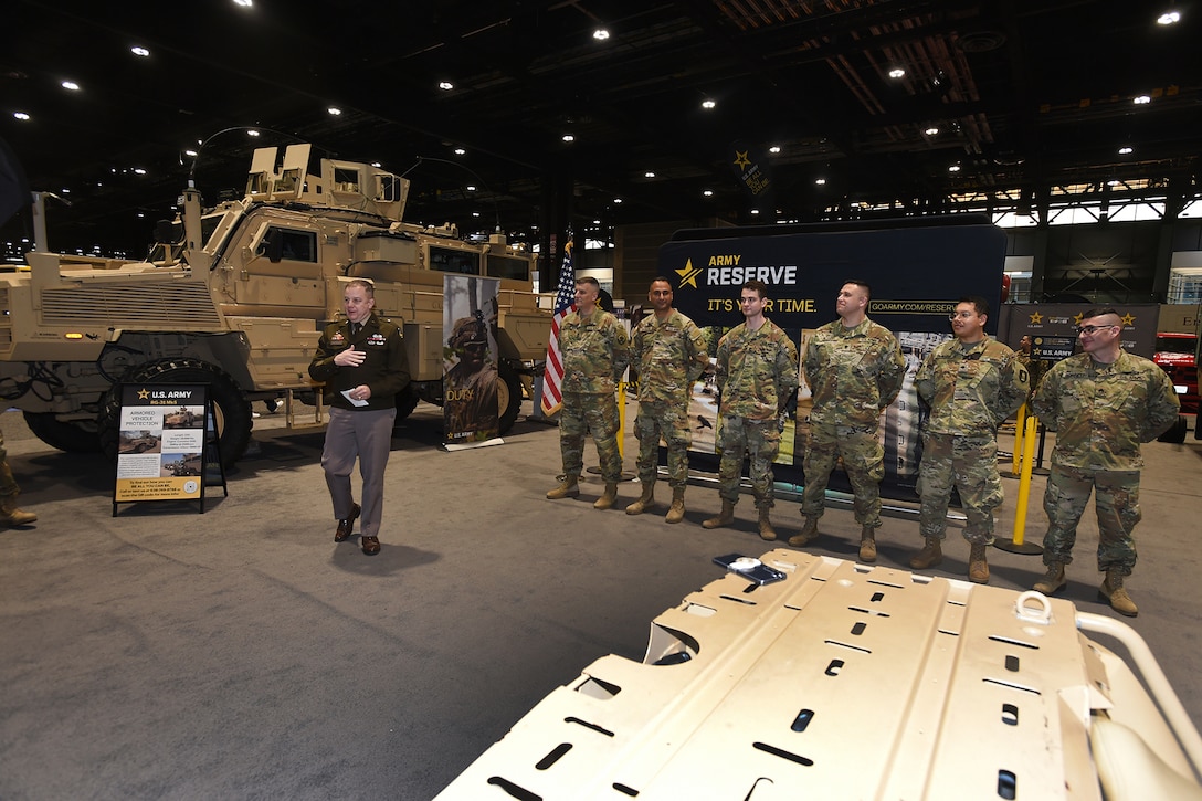 Brig. Gen. Geoffrey Norman, left, Director, Next Generation Combat Vehicle Cross Functional Team, gives brief remarks to the audience before re-enlisting six Army Reserve Soldiers at the Chicago Auto Show on February 13, 2024 at McCormick Place.