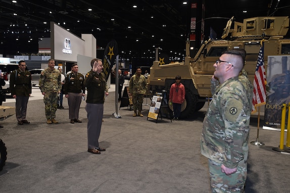 Brig. Gen. Geoffrey Norman, Director, left, Next Generation Combat Vehicle Cross Functional Team, re-enlists six Army Reserve Soldiers at the Chicago Auto Show on February 13, 2024, at McCormick Place.