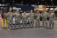 Army Reserve Soldiers, representing a variety of military occupational specialties, from a religious affairs specialist to an infantryman, pause for a photo after a re-enlistment ceremony with Brig. Gen. Geoffrey Norman, Director, Next Generation Combat Vehicle Cross Functional Team, at the Chicago Auto Show on February 13, 2024 at McCormick Place.