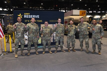 Army Reserve Soldiers, representing a variety of military occupational specialties, from a religious affairs specialist to an infantryman, pause for a photo after a re-enlistment ceremony with Brig. Gen. Geoffrey Norman, Director, Next Generation Combat Vehicle Cross Functional Team, at the Chicago Auto Show on February 13, 2024 at McCormick Place.