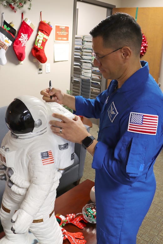 A person signs an astronaut display.