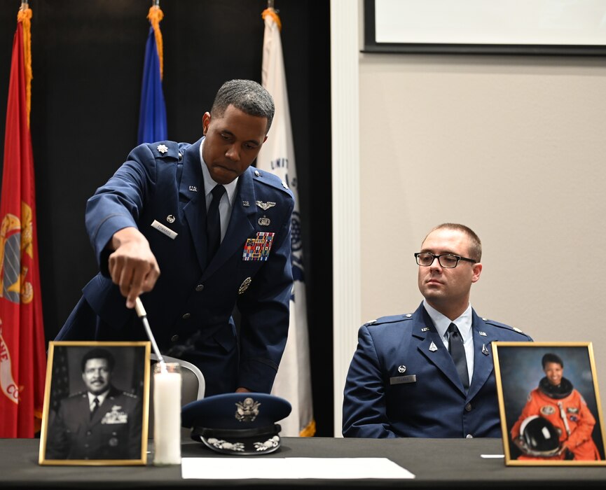 U.S. Air Force Lt. Col. Jahmil Edwards, 316th Training Squadron commander, lights a candle to honor a past hero while U.S. Space Force 533rd Maj. Benjamin Tillman, 533rd TRS Detachment One commander, observes during the Black History Month luncheon at the Powell Event Center, Goodfellow Air Force Base, Texas, Feb. 16, 2024. Black History Month is celebrated every year from February 1st to March 1st. (U.S. Air Force Photo by Staff Sgt. Nathan Call)