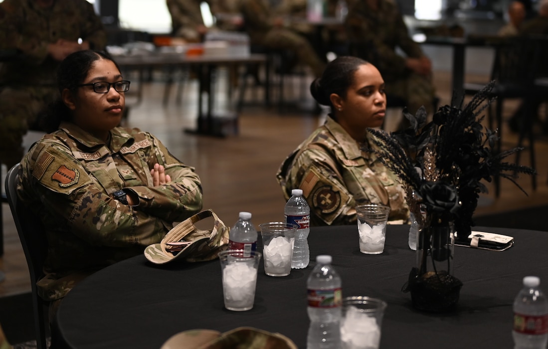 U.S. Air Force Airman 1st Class Evelyn D’Errico and Staff Sgt. Erika Watson listen to speakers who shared stories of African American heroes during the Black History Month luncheon at the Powell Event Center, Goodfellow Air Force Base, Texas, Feb. 16, 2024. Members of the military and local community attended the Black History Month luncheon to honor African Americans in the military. (U.S. Air Force Photo by Staff Sgt. Nathan Call)