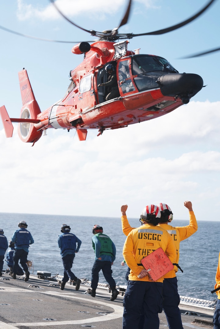 U.S. Coast Guard members assigned to Coast Guard Cutter Thetis (WMEC 910) and an MH-65 Dolphin helicopter crew from the Helicopter Interdiction Tactical Squadron execute in-flight refueling evolutions, Jan. 31, 2024, in the Central Caribbean Sea. Thetis patrolled with an embarked HITRON MH-65 Dolphin helicopter crew to support the Coast Guard’s mission to combat illegal drug trafficking.