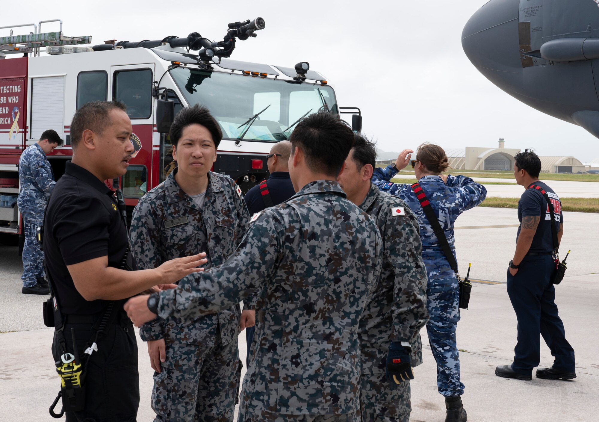 Crispin Pacificar, 36th Civil Engineer Squadron assistant fire chief, briefs Japan Air Self-Defense Force firefighters on emergency response procedures as part of a trilateral firefighter training during Cope North 24 on Andersen Air Force Base, Guam, Feb. 15, 2024. During the training the USAF firefighters discussed hazards, aircraft entry, engine shut-down procedures and emergency rescue procedures on a B-52 Stratofortress, all of which are vital to secure agile combat employment operations. (U.S. Air Force photo by Airman 1st Class Spencer Perkins)